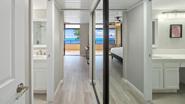 A hallway leading to a bathroom with a shower, a bed, and a view of the outdoors. - Big Island Holualoa Bay Villas by Coldwell Banker Island Vacations (Kailua-Kona)