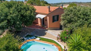 A residential property with a swimming pool, a patio, and a garden.