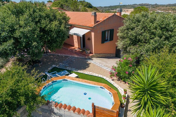 Ein Wohnhaus mit Pool, Terrasse und Garten.