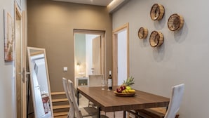 A dining area with a wooden table, chairs, and a fruit bowl. - Holiday Home 'Porto Galini Tinos Perastra 103' with Sea View, Wi-Fi and Air Conditioning (?a??t?)