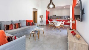 Un salon moderne comprenant un canapé, une table basse et un coin repas avec des chaises.