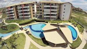 A multi-story residential building with a swimming pool complex. - GranSol, Terreo, Pé na areia, 03 qtos, 08 hóspedes, a 600m do B PARK (Aquiraz)