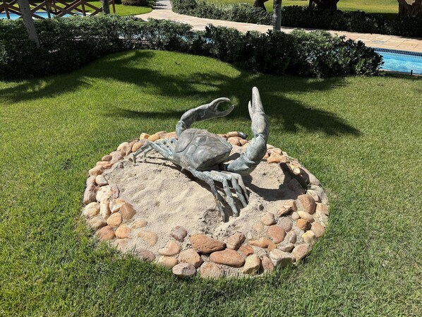 Una escultura de una tortuga sobre un pedestal de piedra rodeada por un círculo de rocas.