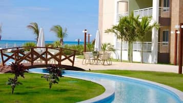 Hotel com piscina, área de estar externa e vista para o oceano.