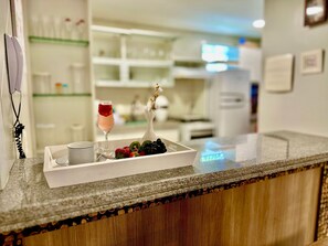 A hotel reception area with a counter, a tray with fruits and a drink, and a telephone. - GranSol, Terreo, Pé na areia, 03 qtos, Até 10 hóspedes, vizinho ao B.PARK (Aquiraz)