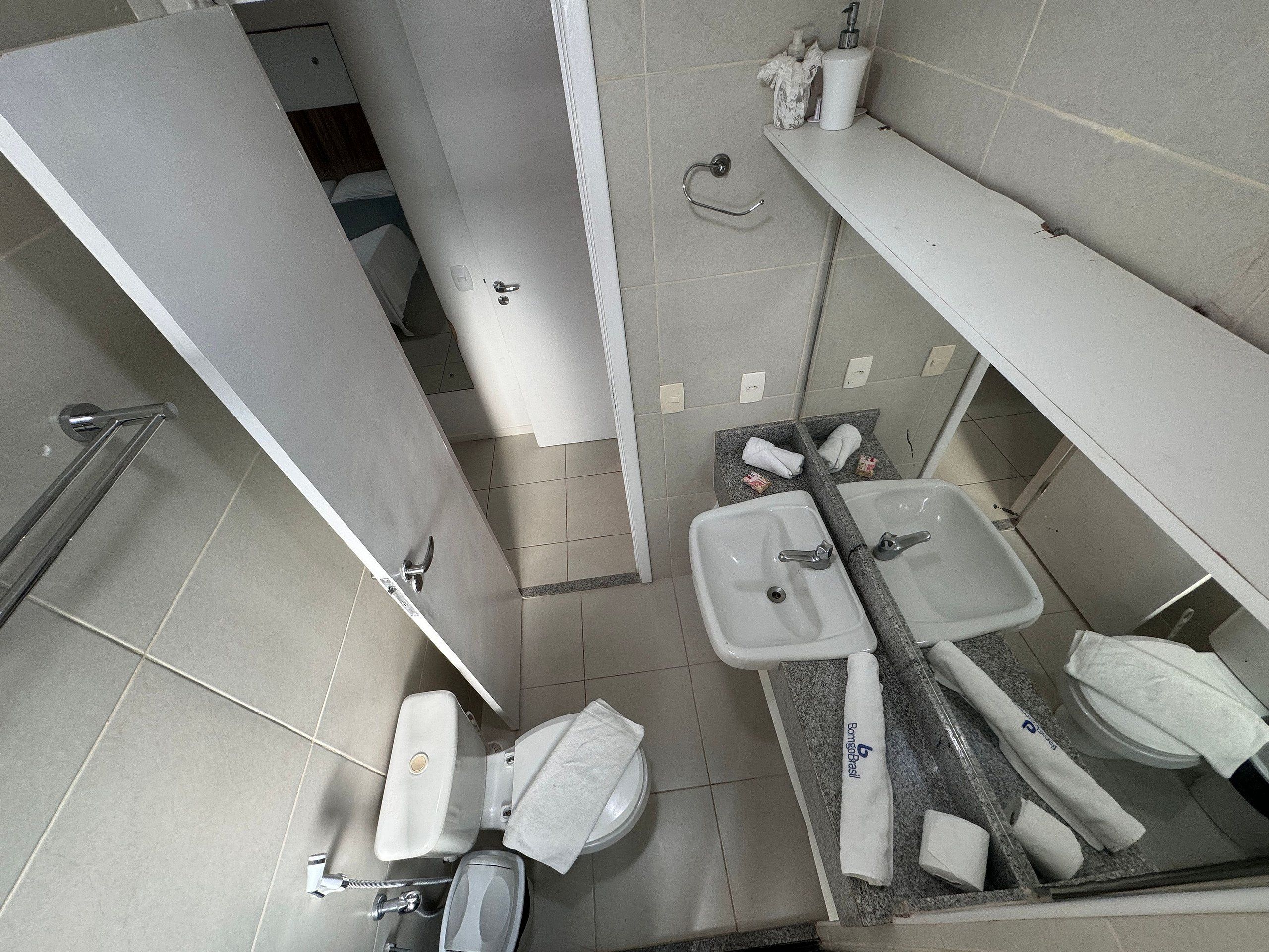A bathroom with a toilet, sink, and towel rack.