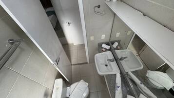 A bathroom with a toilet, sink, and towel rack.
