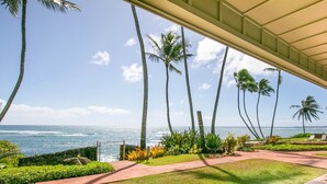A coastal view with palm trees and a pathway leading to a beach. - Kauai Hale Awapuhi By Coldwell Banker Island Vacations (Kapaa)