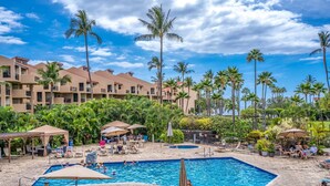 A hotel pool area with multiple pools, palm trees, and lounge chairs. - Kamaole Sands Two Bedrooms by Coldwell Banker Island Vacations (Kihei)