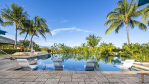 A pool with lounge chairs, palm trees, and a clear sky. - Big Island Waiulaula at Mauna Kea by Coldwell Banker Island Vacations (Kamuela)