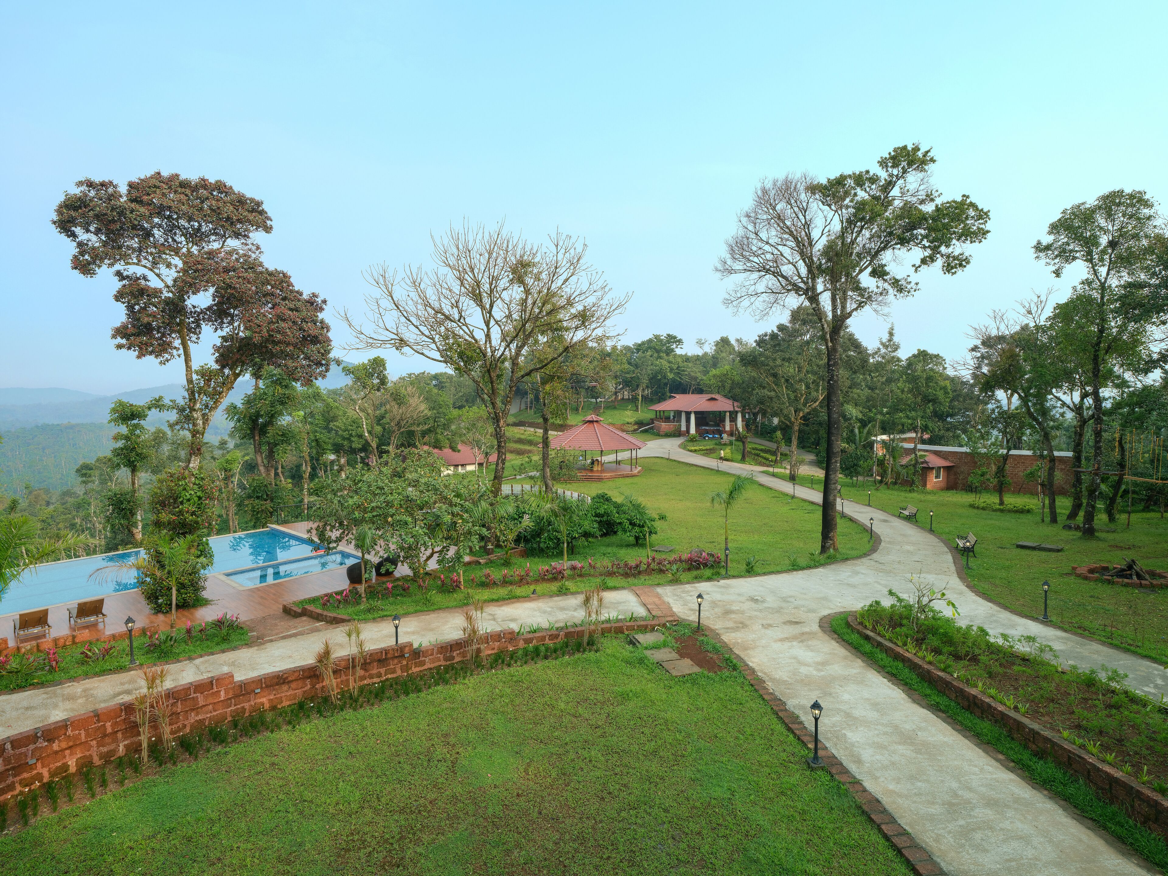 A resort with a swimming pool, a gazebo, and a well-maintained lawn.