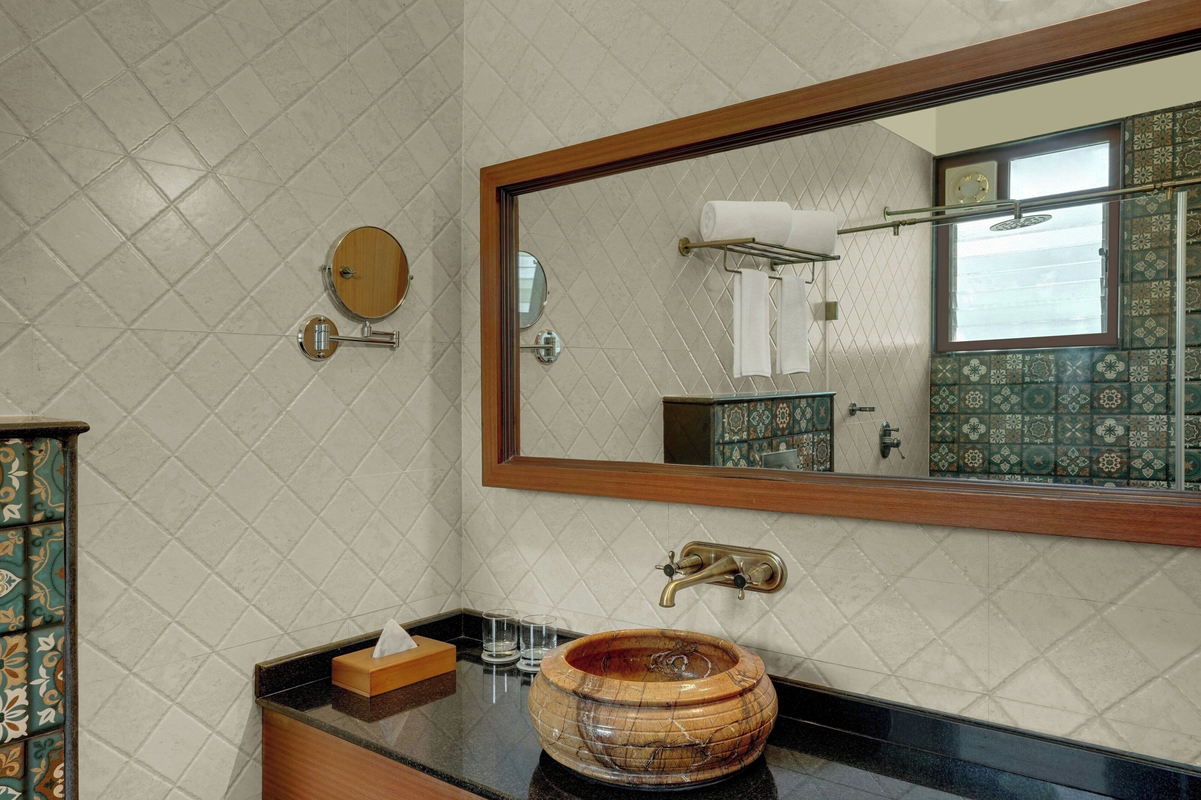 A bathroom with a wooden bowl sink, a mirror, and a towel rack.
