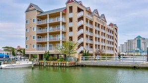 A multi-story hotel with balconies, located near a body of water. - Beach Paradise VIII-DOWNTOWN WATERFRONT 3BR Luxury Condo POOL-Beach-Boardwalk (Ocean City)