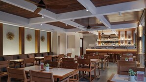 A modern restaurant interior with wooden furniture, a bar area, and decorative wall panels. - Chesa Canggu (Canggu)