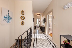 A hallway with a patterned floor, a staircase, and wall-mounted decorations. - Rustic Villa Okra With Pool (Opatija)