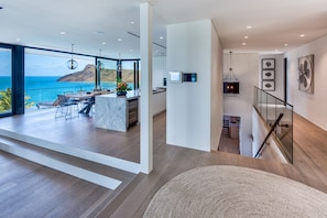 Un intérieur moderne comprenant une cuisine, un coin repas et un balcon avec vue sur la mer.