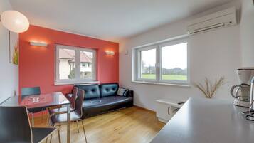 Relax in this stylish living space with a sofa, dining table, and kitchenette.