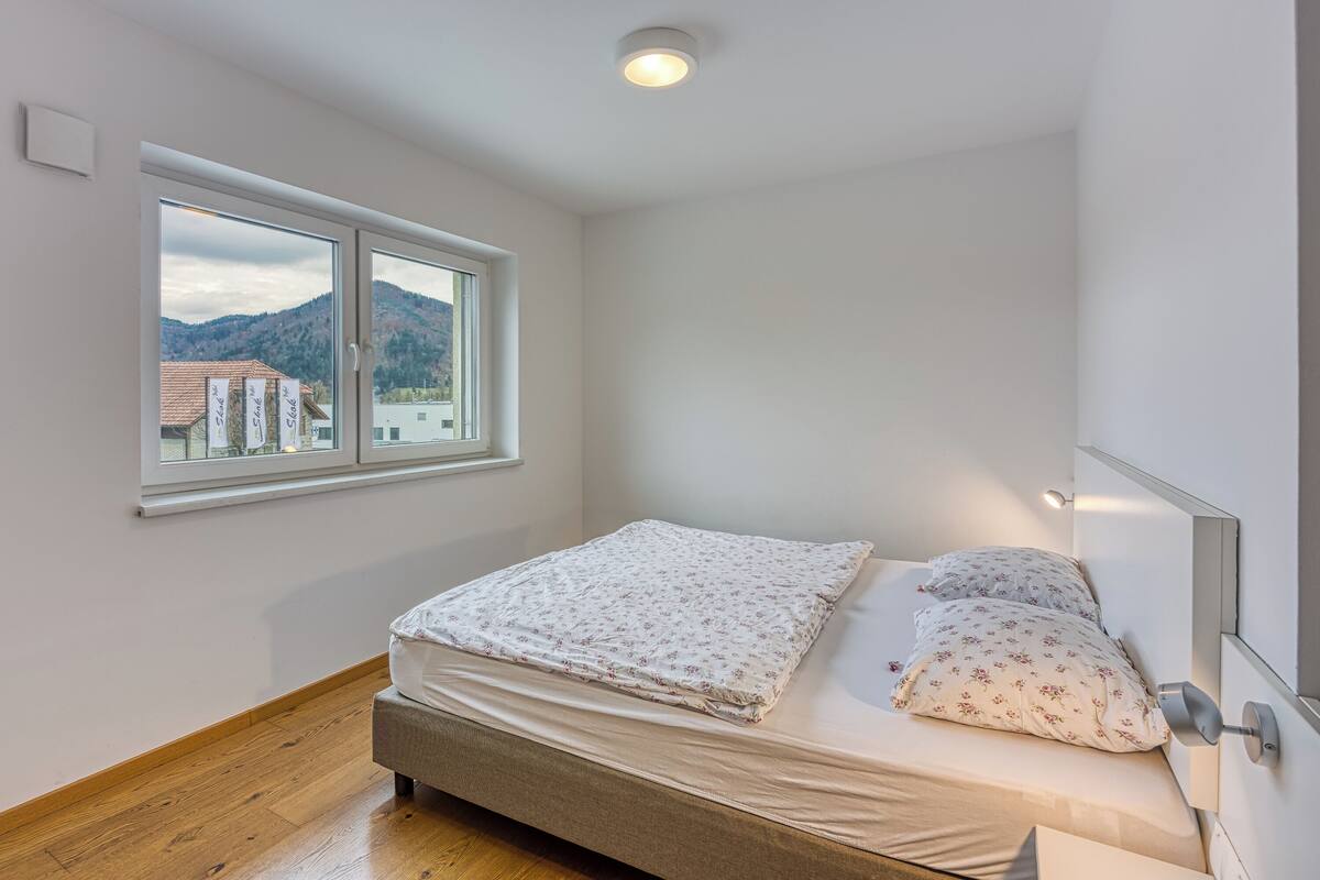 Une chambre à coucher avec un lit, une fenêtre et une vue sur une montagne.