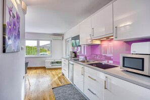 Familienapartment, 1 Schlafzimmer, Bergseite (Wellness Suite Viola) | Eigene Kochnische | Kühlschrank, Mikrowelle, Ofen, Herdplatte