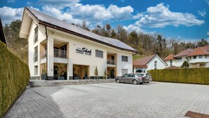 A two-story building with a sign reading "Skok Apartments Wellness." - Honeycomb Chalets and Apartments Mozirje (Mozirje)