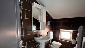 Ein modernes Badezimmer mit Dusche, Waschbecken und Toilette.