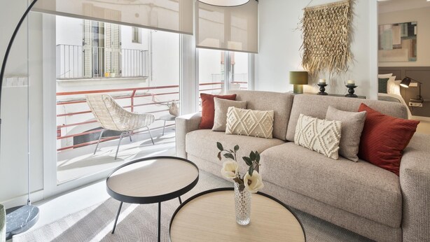 Un salon moderne avec un canapé, une table basse ronde et un grand lampadaire.