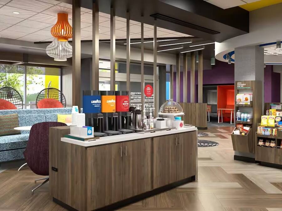 A modern cafe with a counter, seating area, and a snack display.