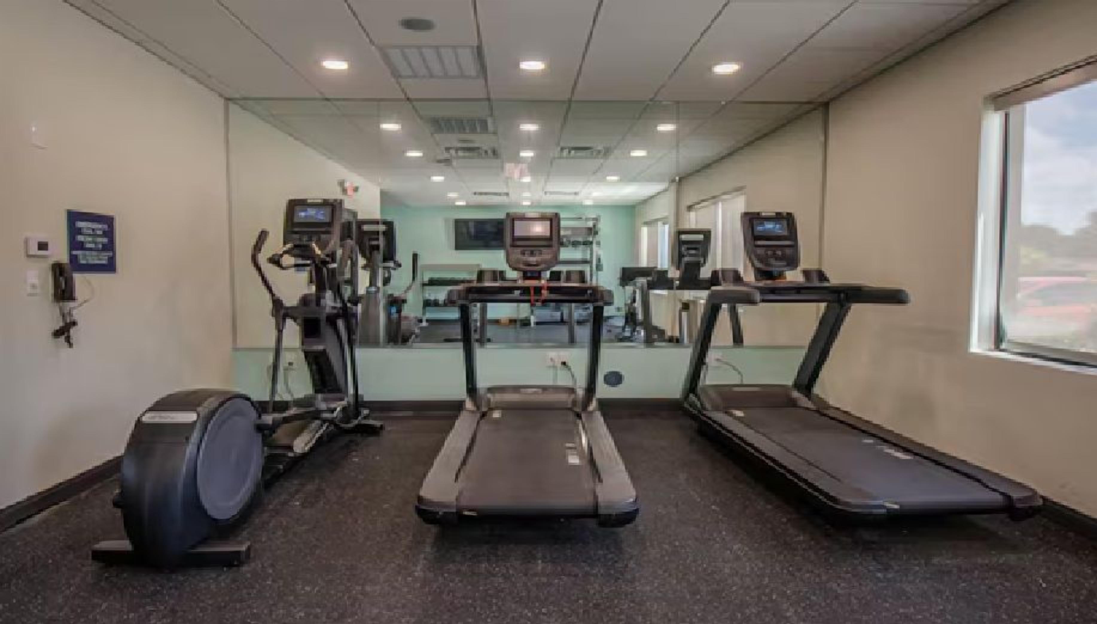 A gym with treadmills, a stationary bike, and a rowing machine.