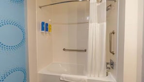 A modern shower stall with a glass door, a towel rack, and a handrail. - Tru By Hilton Mckinney (McKinney)