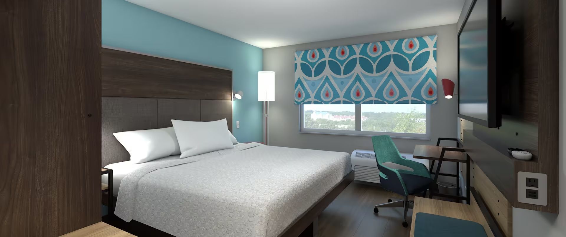 A hotel room with a bed, a desk, a chair, a TV, and a window with a view.