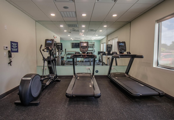 A gym with treadmills, elliptical machines, and a mirrored wall. - Tru By Hilton Mckinney (McKinney)