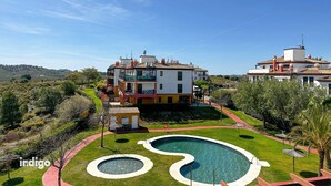 Un quartier résidentiel comprenant deux immeubles à plusieurs étages, une piscine et un petit jardin.