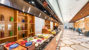 A buffet area with various food items and a long counter. - Madison Hotel Taizhou Jingqi (Taizhou)
