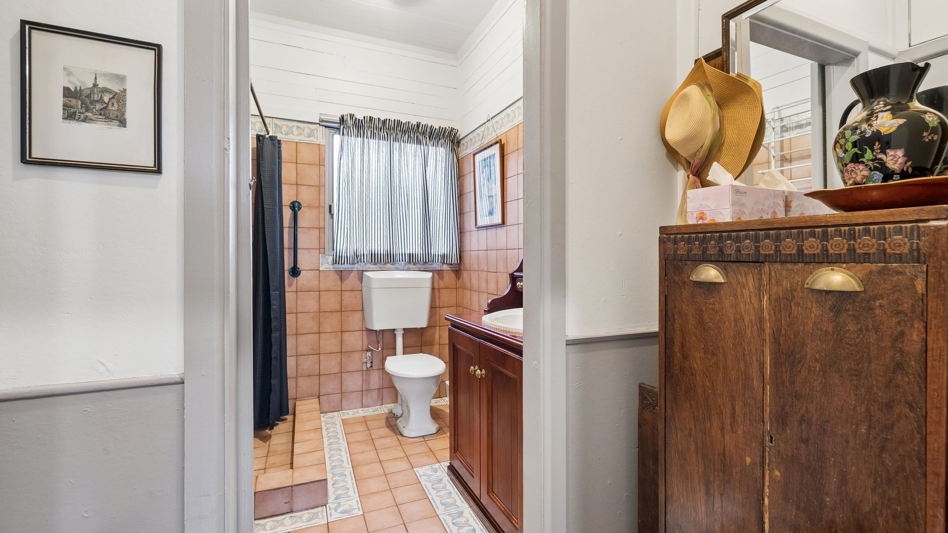 Une salle de bain avec des toilettes, un lavabo et un rideau de douche.