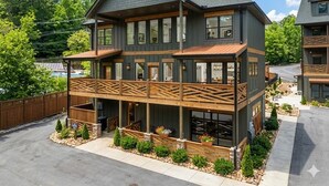 Ein zweistöckiges Gebäude mit Balkon, überdachter Veranda und Natursteinfundament.