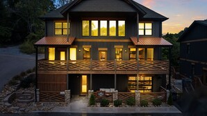 A two-story house with a balcony, a garage, and a driveway.