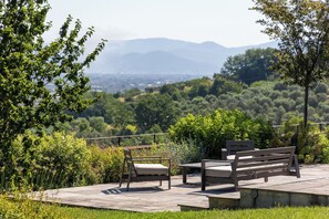 Un banc et une table dans un jardin offrant une vue sur la ville et les montagnes.
