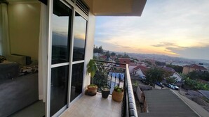 Ein Balkon mit großen Schiebeglastüren, einer Couch und Topfpflanzen.