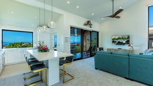 Una cocina moderna con una isla grande, taburetes de bar y luces colgantes.
