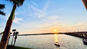 A sunset over a calm body of water with a pier extending into the water.