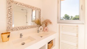 A bathroom with a white vanity, two sinks, a large mirror with an ornate frame, a window with a view of trees, and a radiator. - VILLA CAMELIA- 5 bedrooms, sea view, swimming pool (ALBITRECCIA)