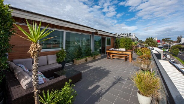 A modern outdoor patio with a sofa, table, and potted plants. - Beautiful 1-bed in St Kilda w/ Parking & Terrace (St Kilda)