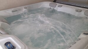 Un bain à remous doté d’un panneau de commande et de plusieurs jets.