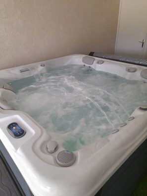 A hot tub with a control panel and multiple jets.