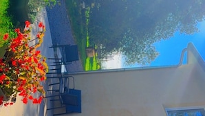 Une cour avec un espace aménagé pour s’asseoir, une porte et une fenêtre.