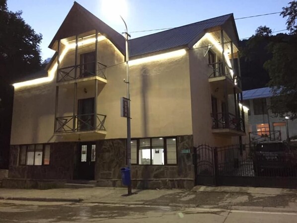 A two-story building with a balcony on the second floor, a stone facade, and a gated entrance. - Hotel Gera (Mestia)
