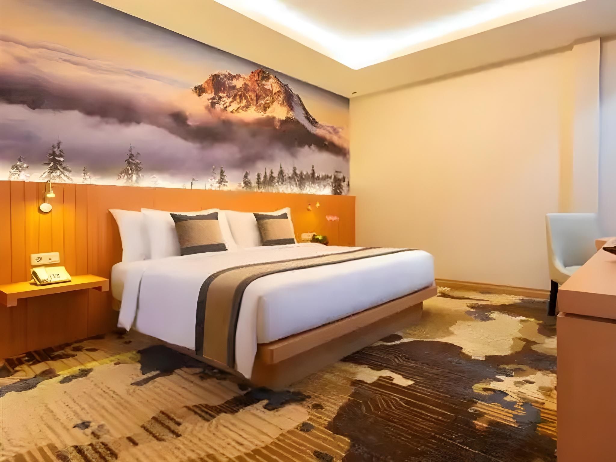 Una habitación de hotel con una cama, mesitas de noche, un escritorio y un mural grande en la pared.