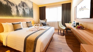 Une chambre d’hôtel avec un lit, un bureau, une chaise, une télévision et un tableau au mur.