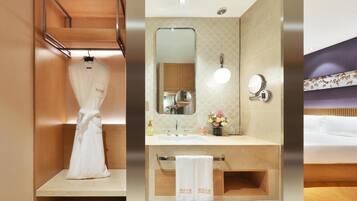 A hotel room with a wooden vanity, a mirror, a sink, and a bed.