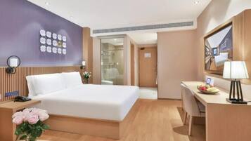 Una camera d'albergo con un letto, una scrivania e uno specchio.